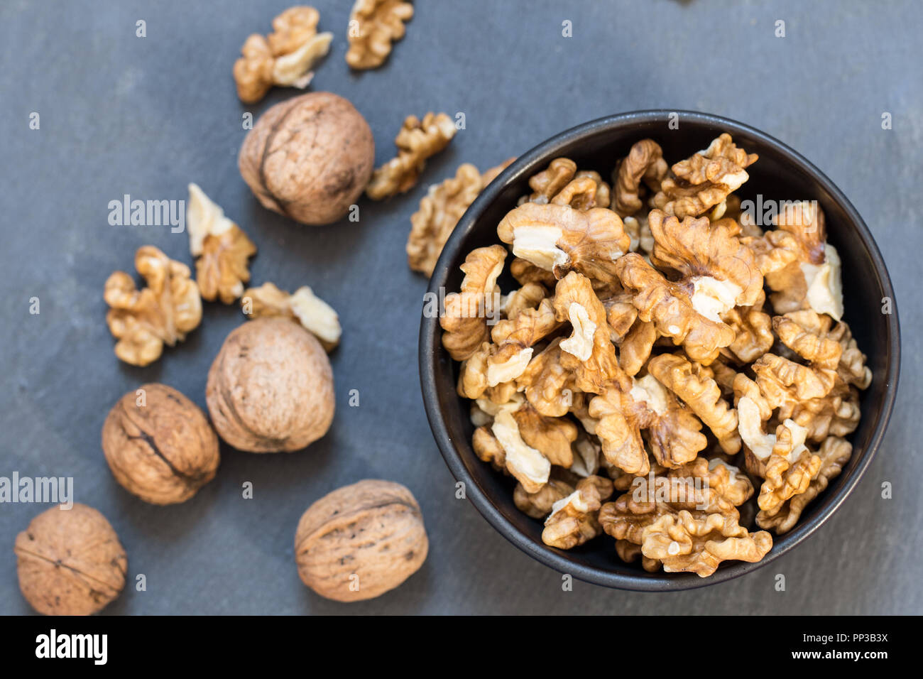 peeled and whole walnuts table top view Stock Photo