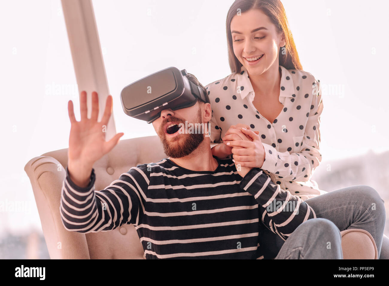 Bearded surprised man wearing virtual reality glasses Stock Photo