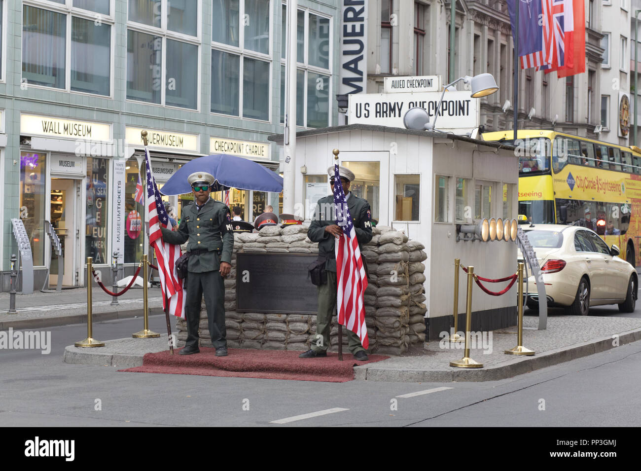 Actors holding flags at checkpoint charlie for tourism in Berlin ...