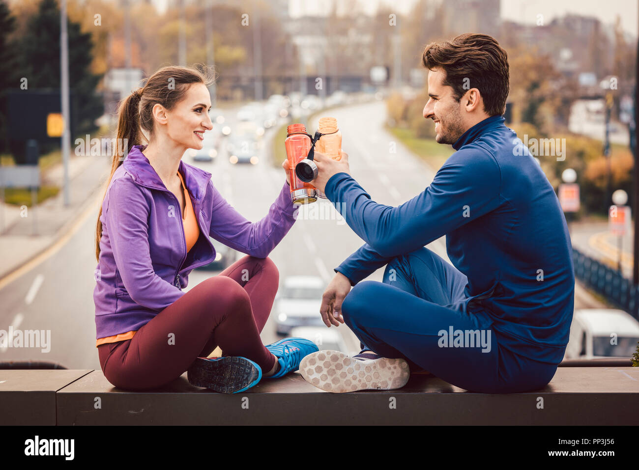 Woman and man drinking water in break from fitness training Stock Photo
