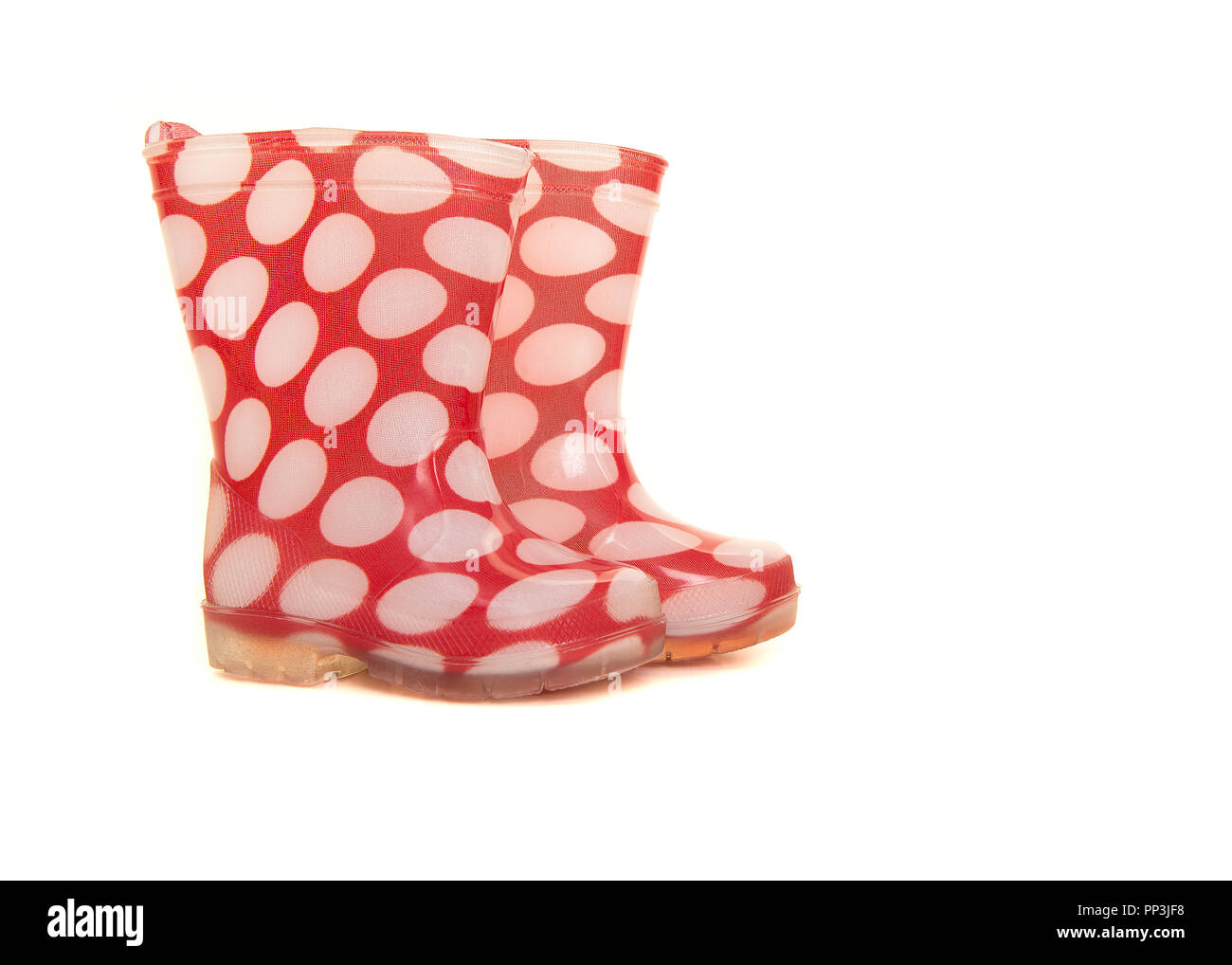 Red and white polka dotted rainboots for kids isolated on a white background Stock Photo