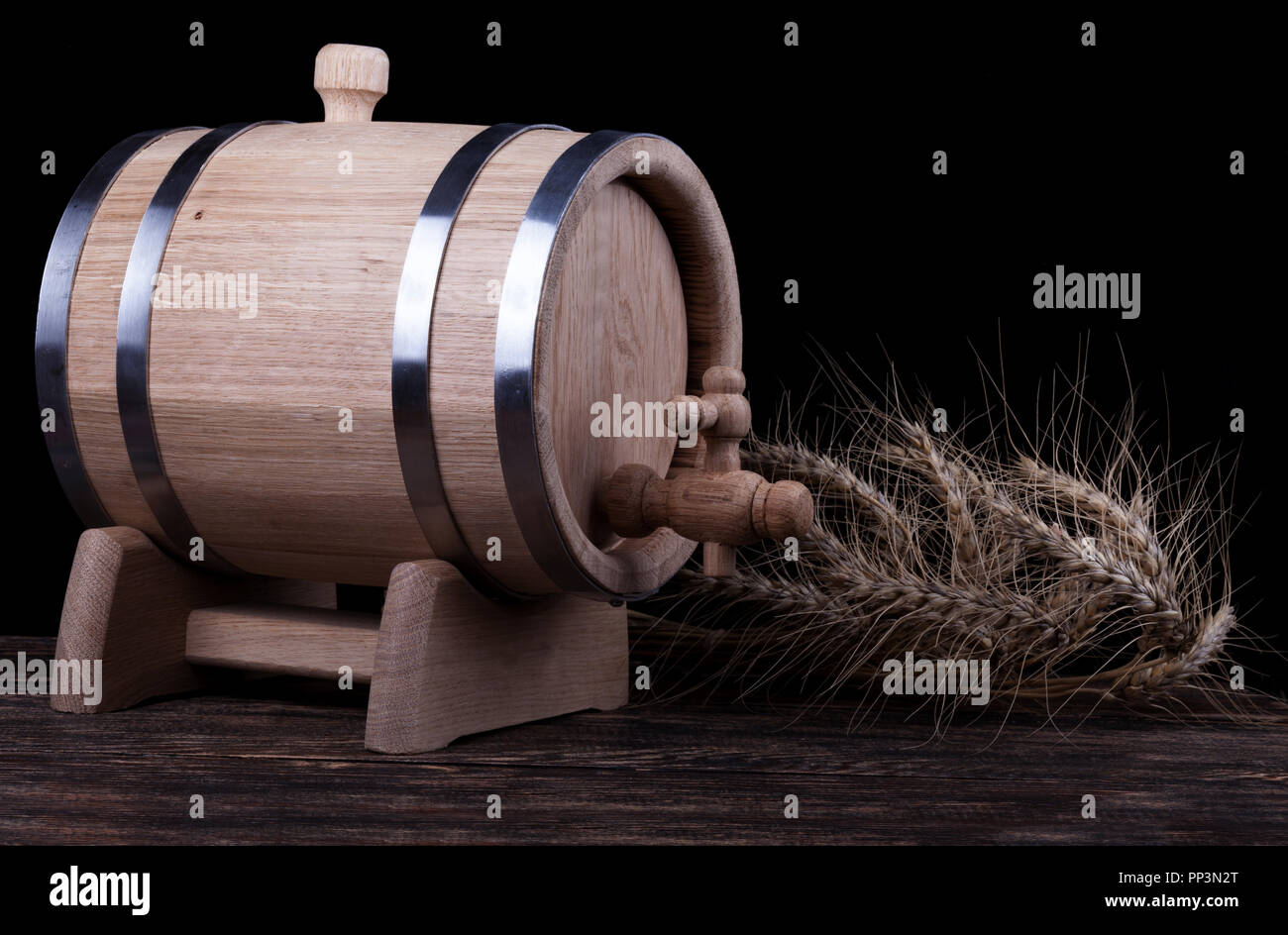 Wooden barrel with rye crops on wooden table close up Stock Photo
