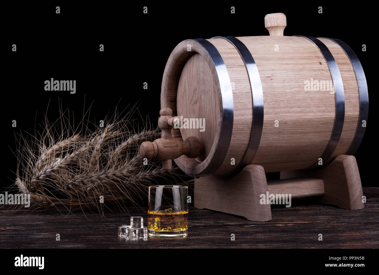 Wooden barrel with rye crops on wooden table close up Stock Photo