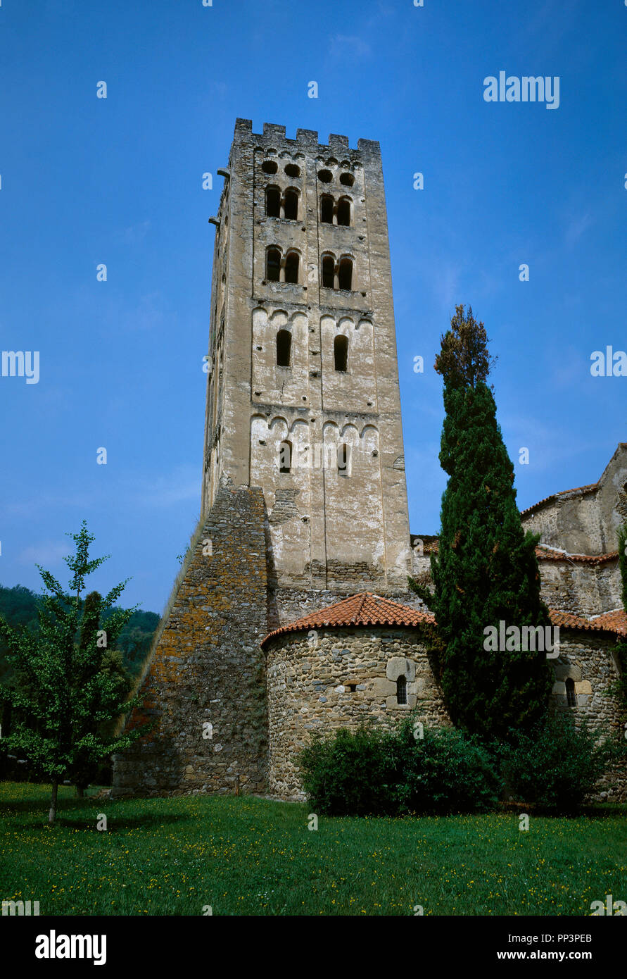 France. Pyrenees-Orientales department. Abbey of Saint-Michel de Cuxa. Benedictine abbey. Romanesque bell tower, Lombard style, 11th century. Single windows in the two lower floors and double in the two upper floors. The buttress is dated in 14th century. Stock Photo