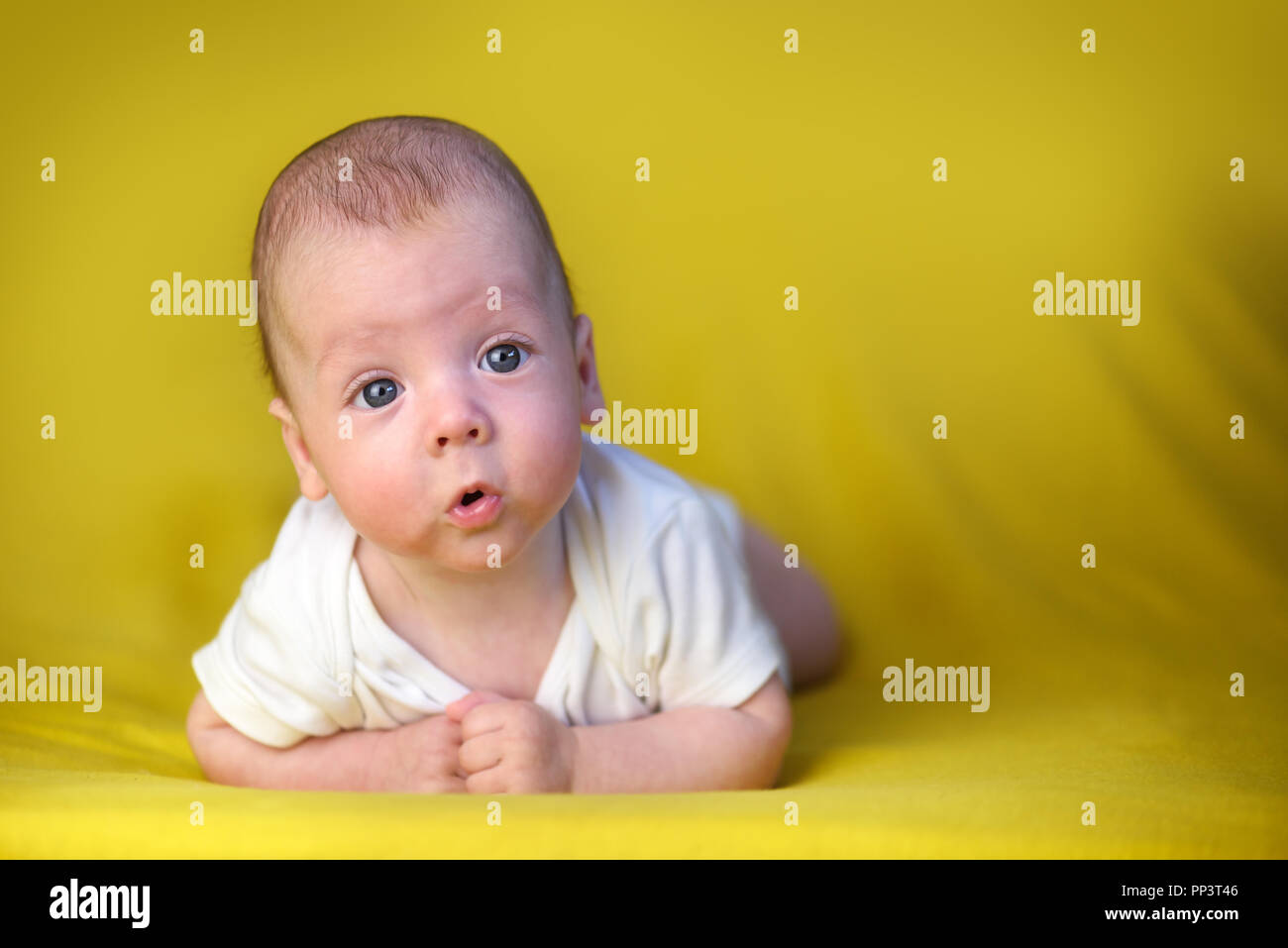 Newborn baby boy portrait on yellow carpet closeup. Motherhood and new life concept Stock Photo