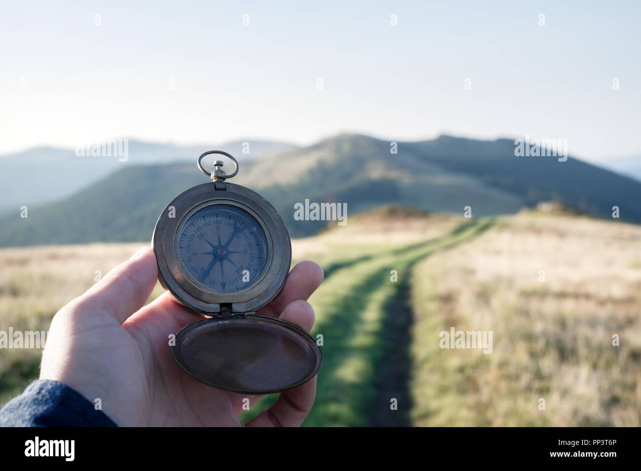 Man with compass in hand on mountains road. Travel concept. Landscape photography Stock Photo