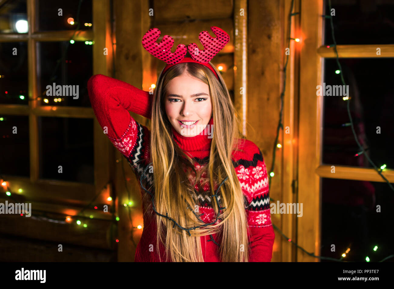 Beautiful girl with festive lights in a log cabin Stock Photo