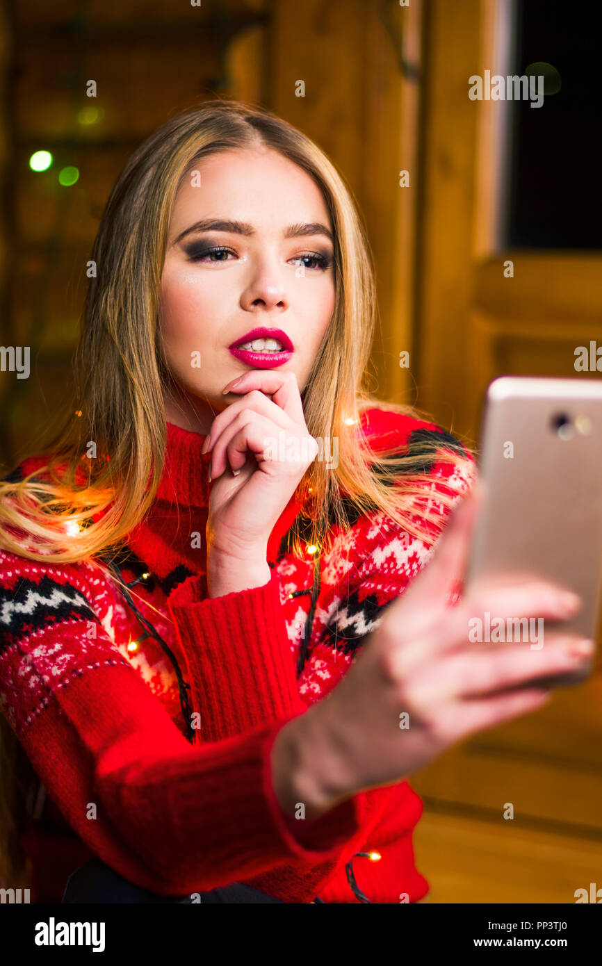 Beautiful girl taking a selfie with festive lights background Stock Photo