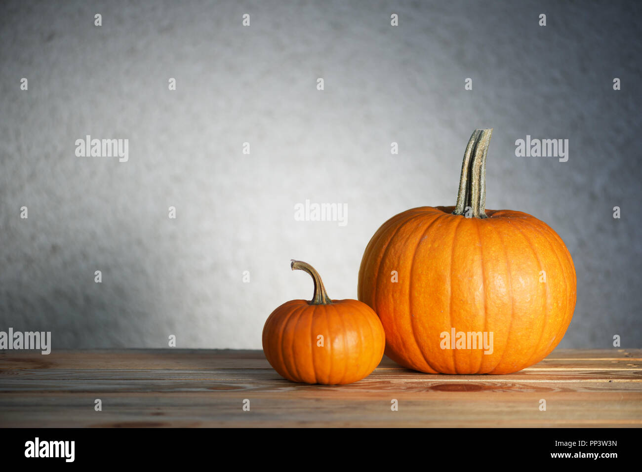 Two pumpkins on wooden table. Halloween and autumn food background Stock Photo