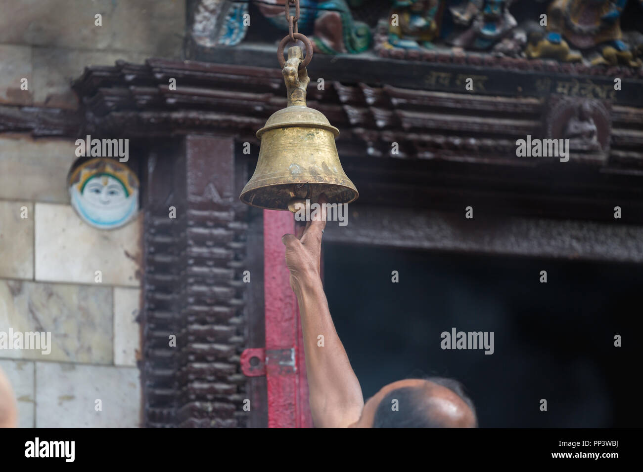 A Hindu devotee ringing temple bells  in the temple of Kathmandu Nepal. Stock Photo