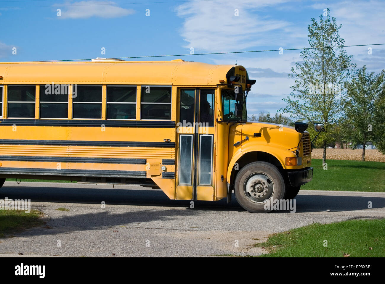 yellow school bus stopped on road Stock Photo