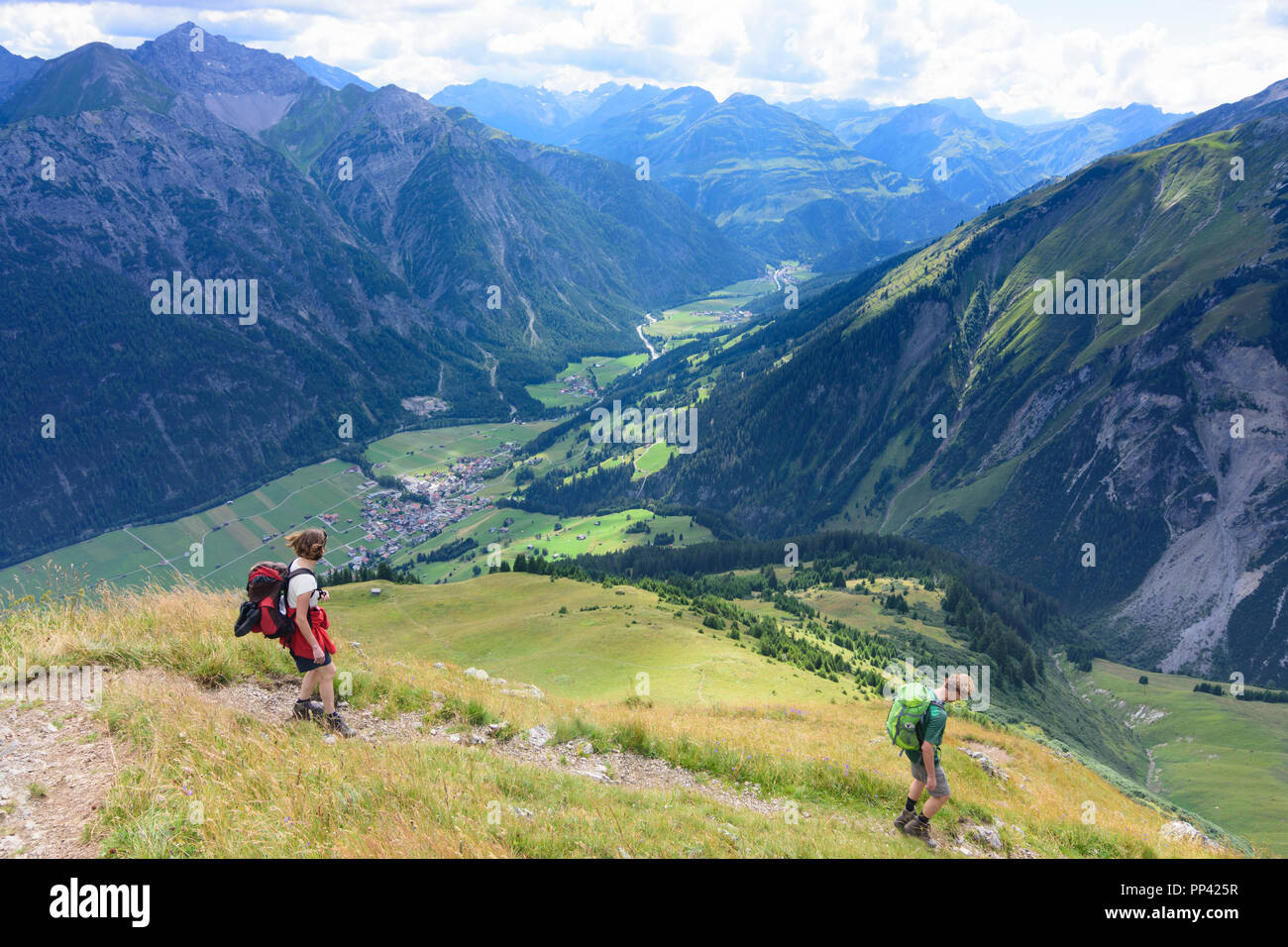 Holzgau: hiker descending to Lechtal (valley of river Lech) and village Holzgau, Lechtal Valley, Tirol, Tyrol, Austria Stock Photo