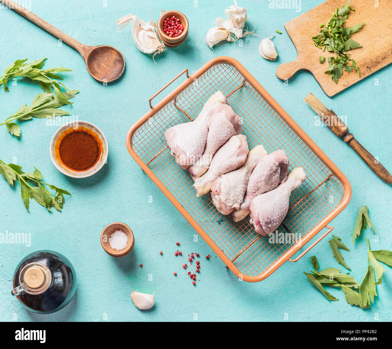 Raw chicken drumsticks for grill or roasting on roast grid with marinate, spice and seasoning on