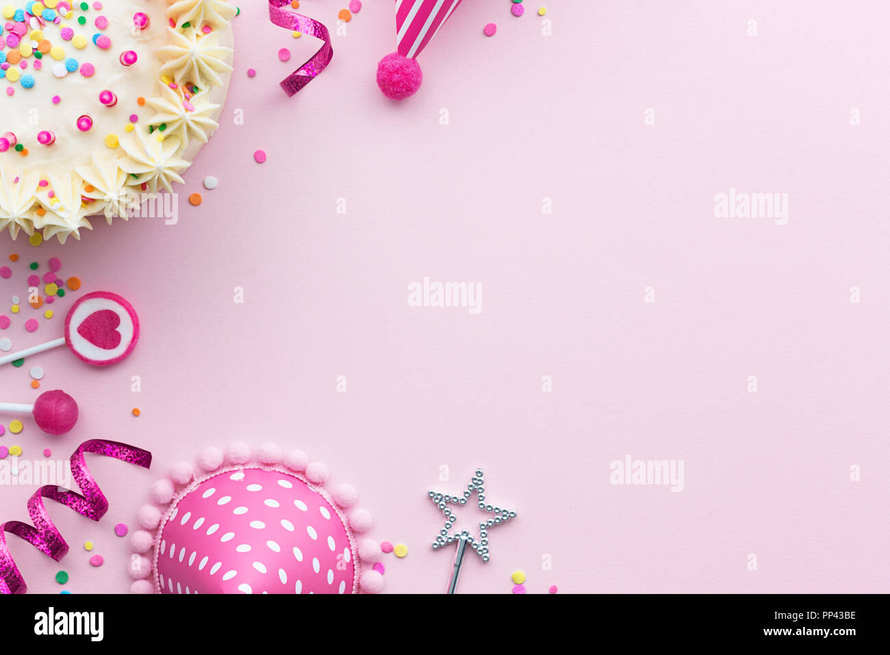 Pink birthday party background with birthday cake and party hats Stock Photo