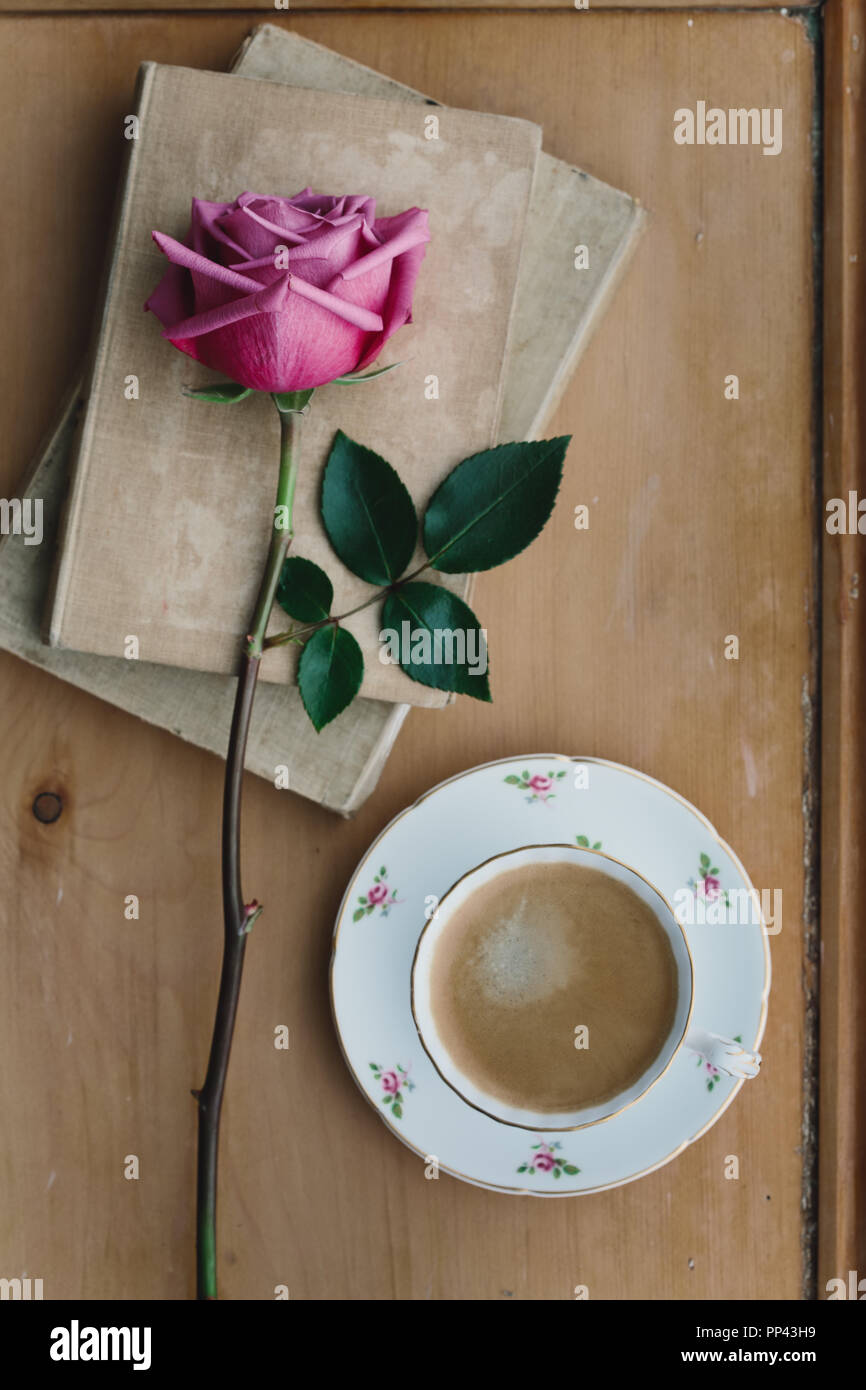 Coffee in a vintage teacup with a faded pink rose Stock Photo