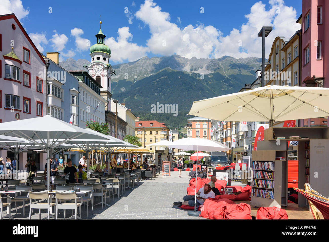Innsbruck: street Maria-Theresien-Straße, column Annasäule, church Spitalskirche, mountain Nordkette, people at reading festival, Region Innsbruck, Ti Stock Photo