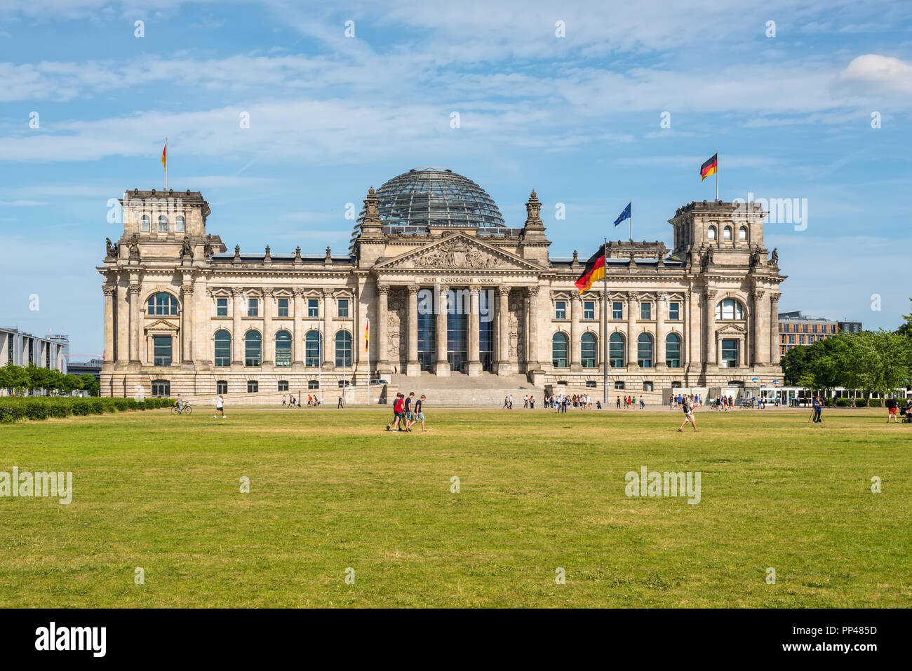 Berlin, Germany - May 28, 2017: Reichstag building, German Parliament (Deutscher Bundestag), people enjoying a spring day. The dedication Dem deutsche Stock Photo