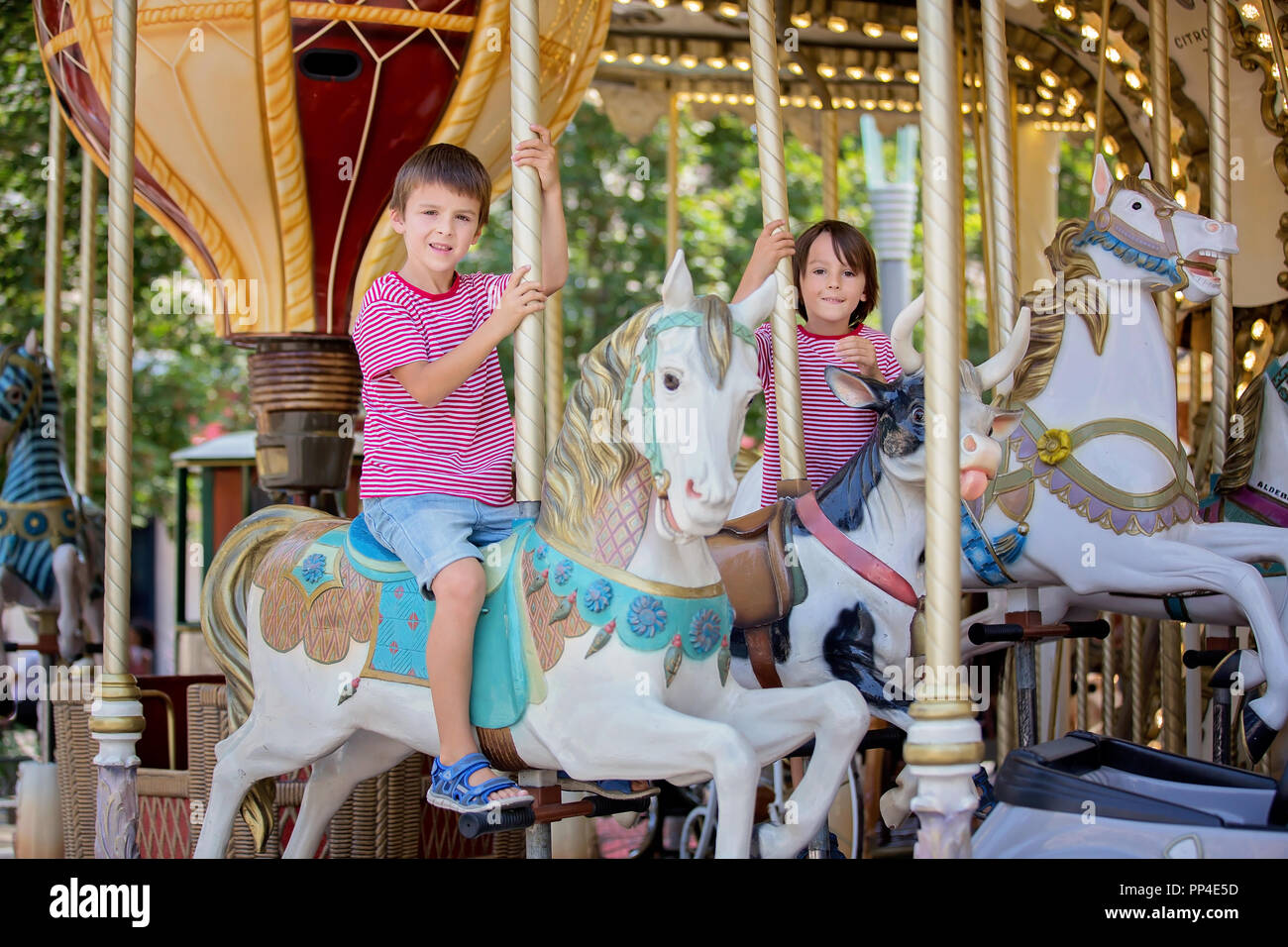 Children going on Merry Go Round, kids play on carousel in the summer Stock Photo Alamy