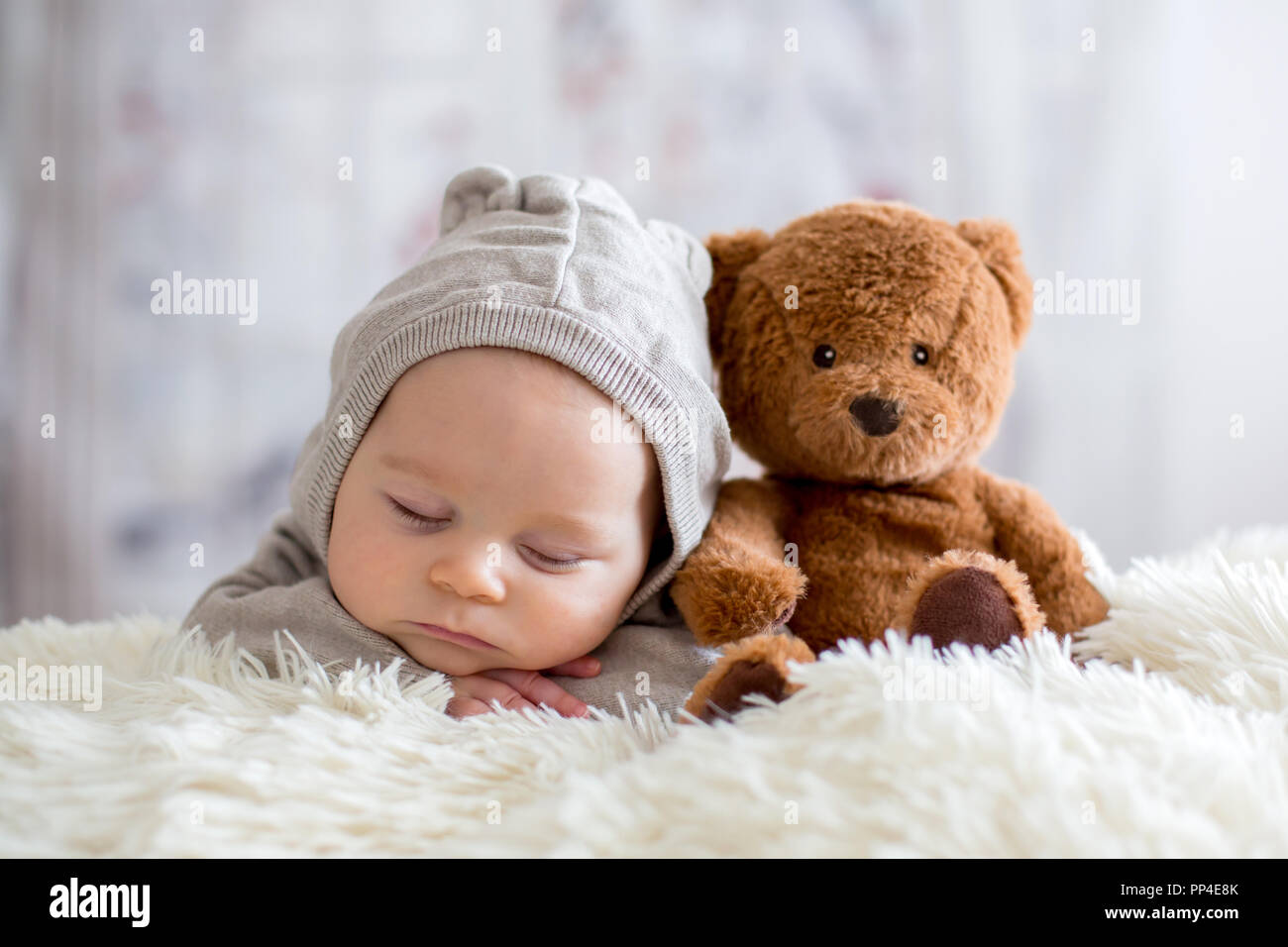 Sweet baby boy in bear overall, sleeping in bed with teddy bear stuffed  toys, winter landscape behind him Stock Photo - Alamy