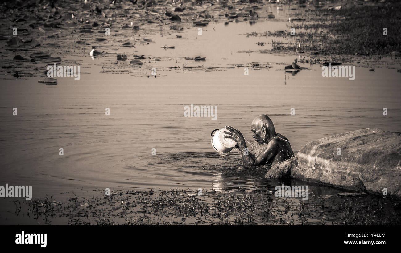 Old man showering in lake, Sri Lanka Stock Photo