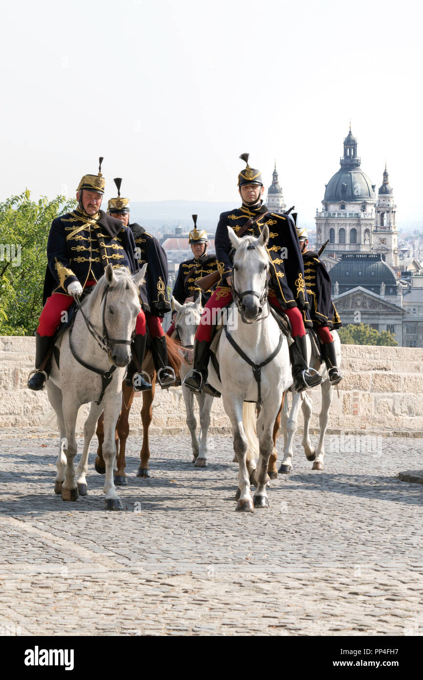 Hungarian Hussars on horseback on duty at Budapest's Castle Hill with St Stephen's Basilica in background Stock Photo