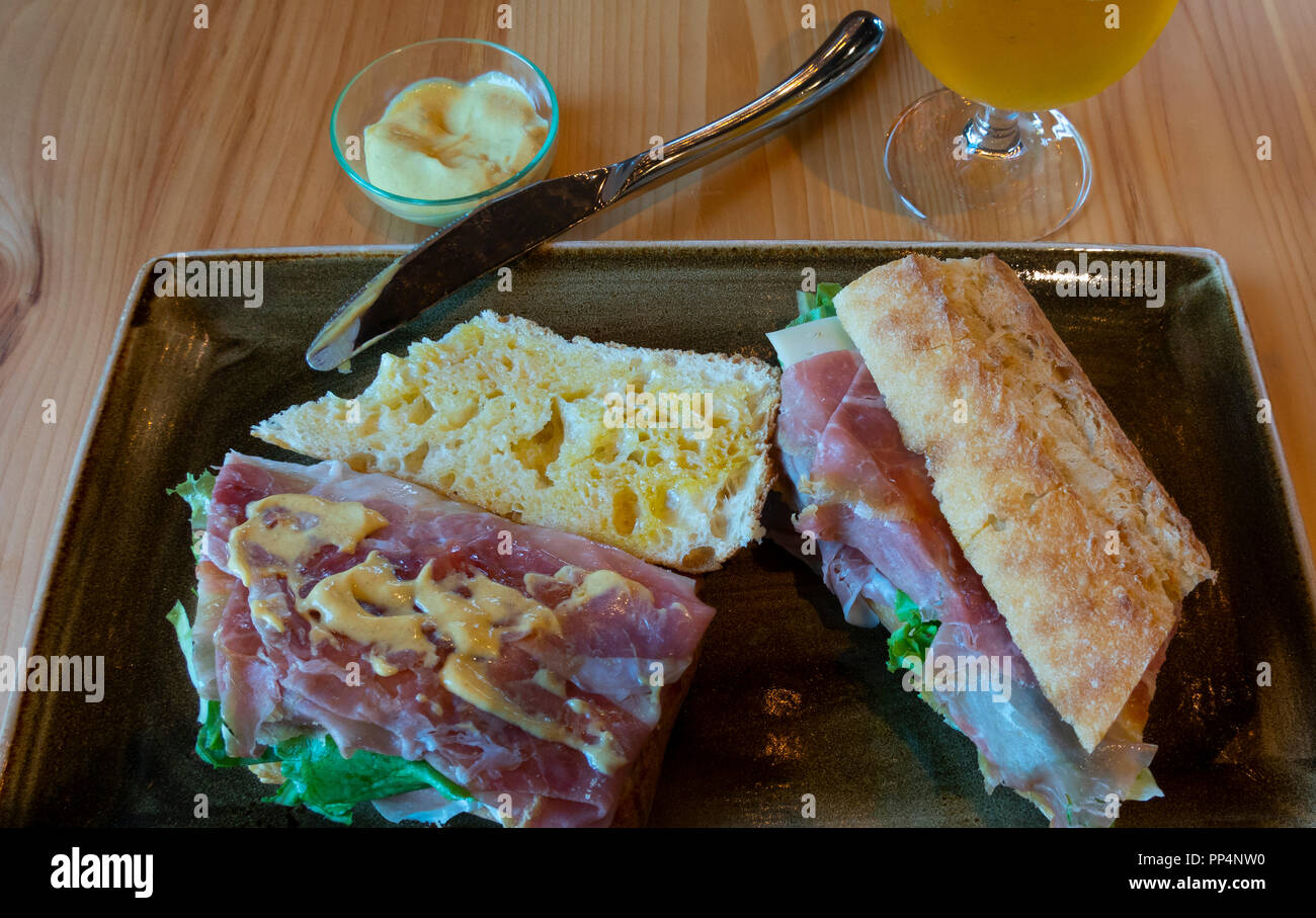 Ham and cheese sandwich on French bread with Dijon Mustard and a glass of beer at a bistro in Montreal, QC, Canada Stock Photo