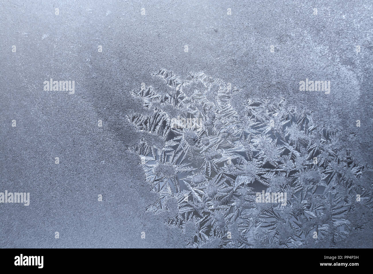 Homogeneous white frozen window with spot of frosty pattern of ...