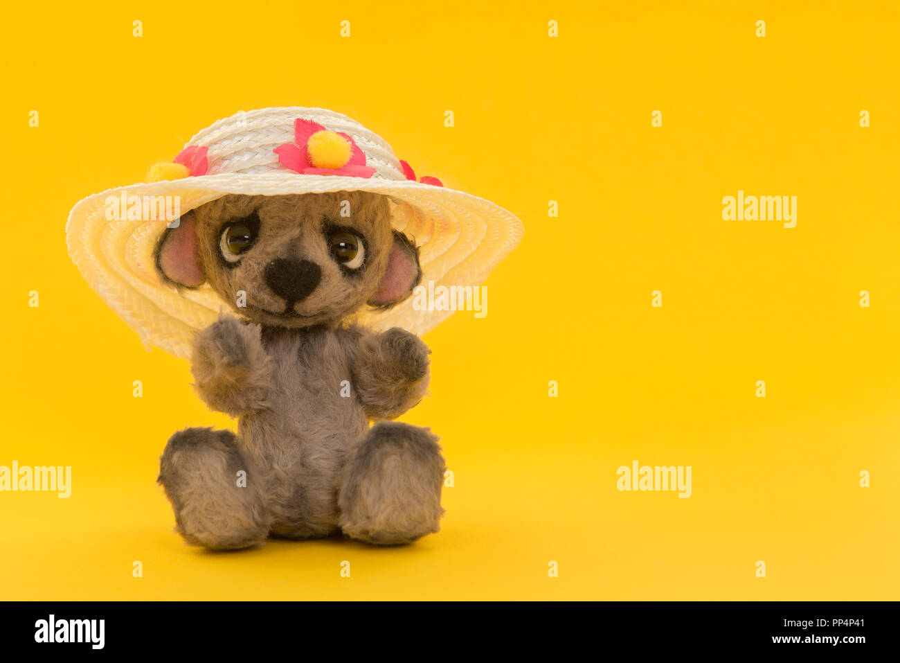 Adorable teddy bear with summer hat on a yellow background Stock Photo ...