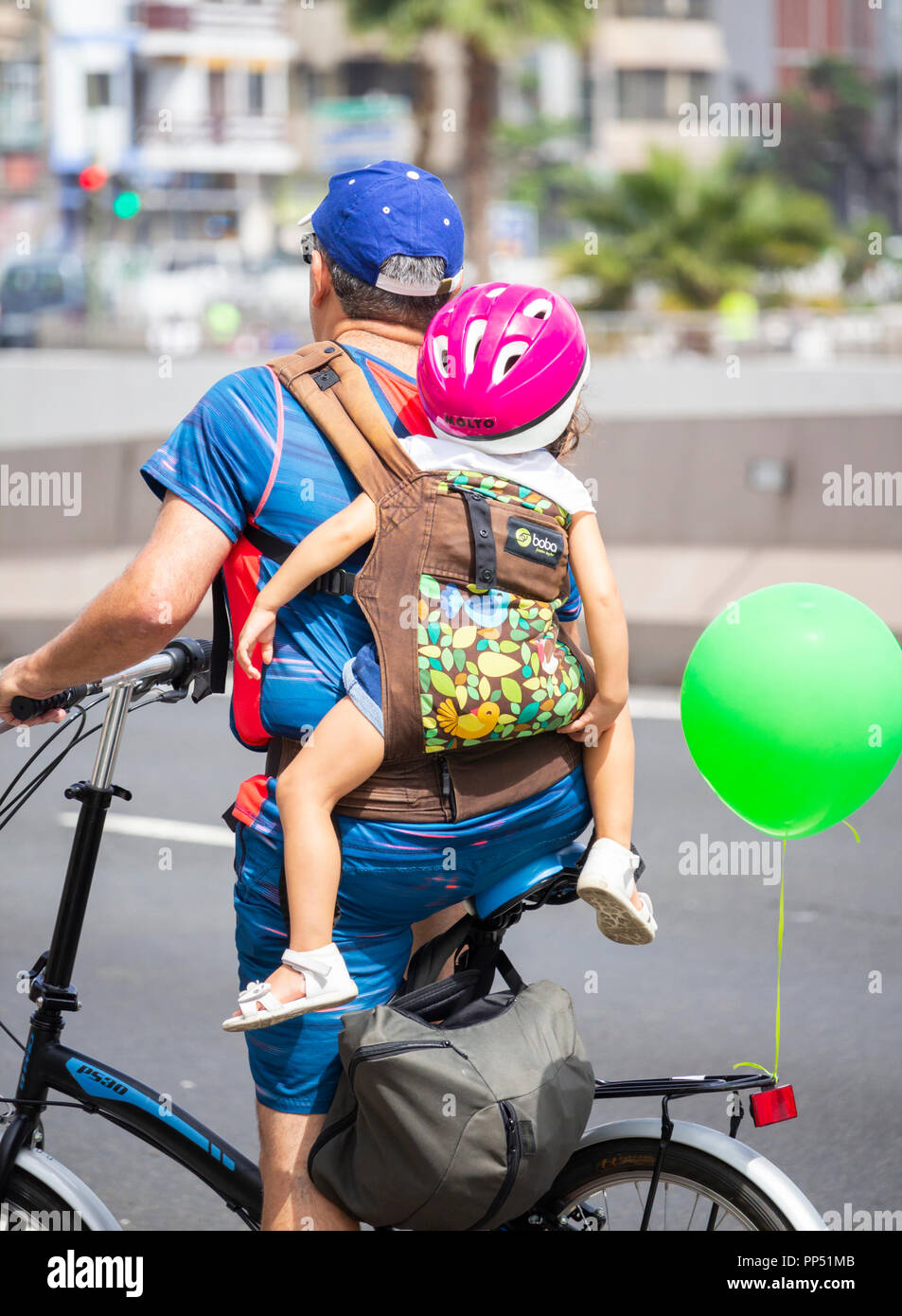 Cyclist carrying child on back. Stock Photo