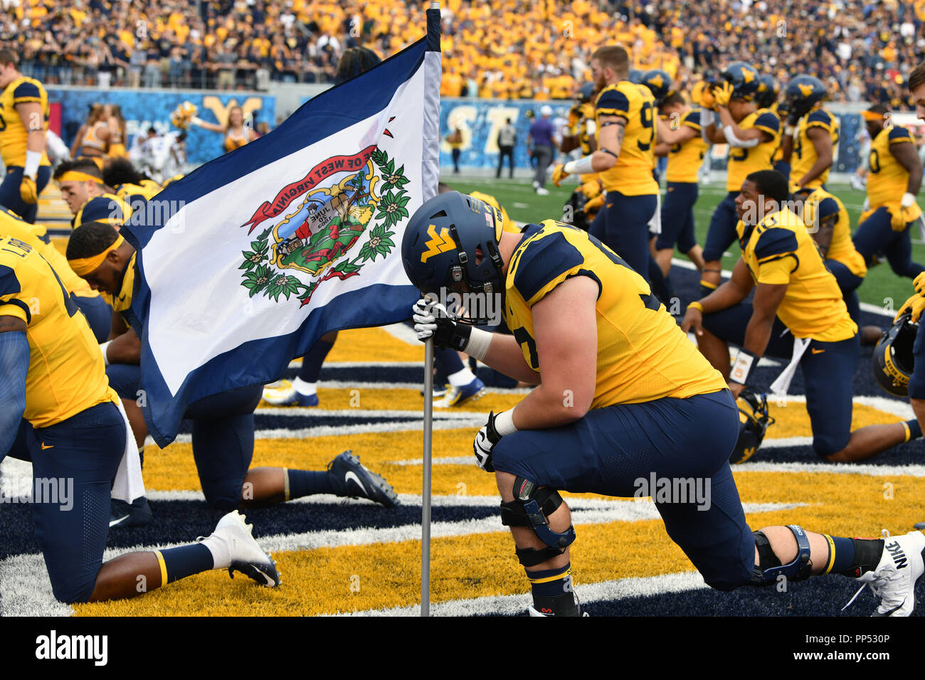 Morgantown, West Virginia, USA. 22nd Sep, 2018. West Virginia Mountaineers  offensive lineman COLTON MCKIVITZ (53) carries the state flag onto the  field prior to the Big 12 football game played at Mountaineer