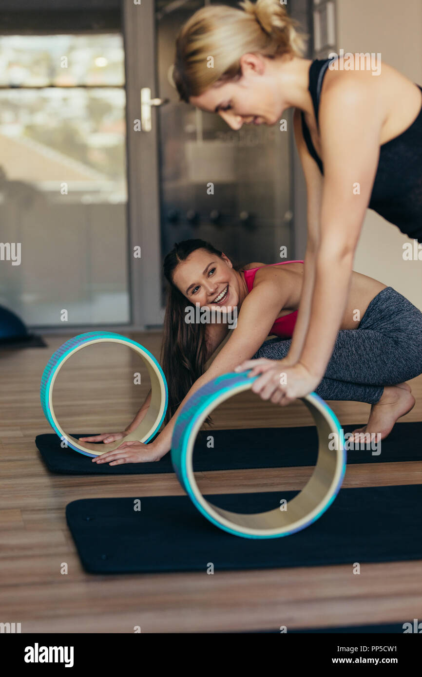 Fitness woman doing pilates workout using a yoga or pilates wheel. Woman in  push up position resting hands on pilates wheel Stock Photo - Alamy