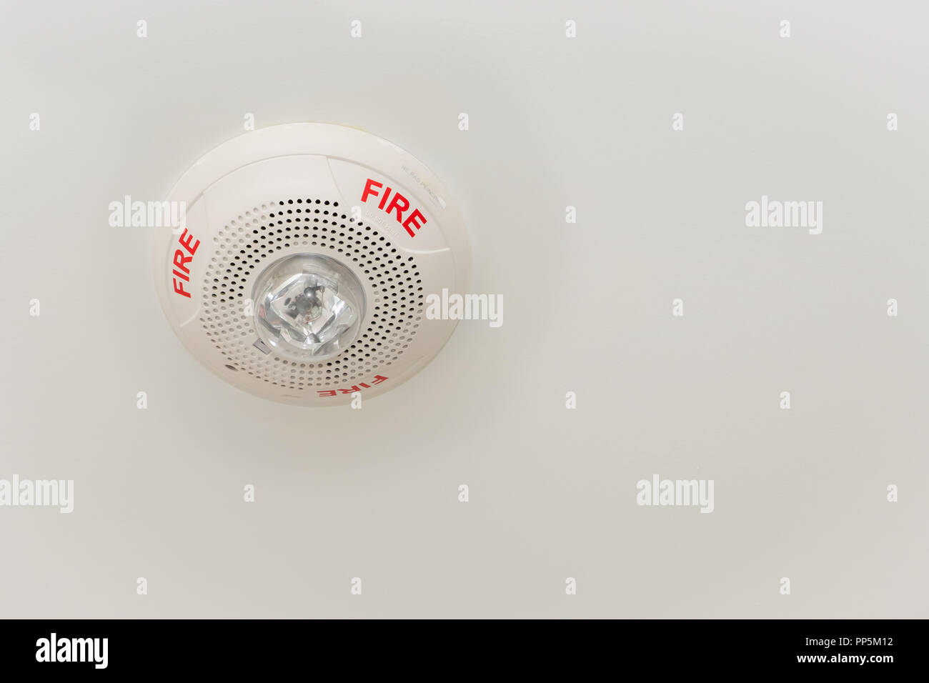 Fire alarm communication component mounted on the ceiling of a residential unit, part of a comprehensive life safety system. Stock Photo