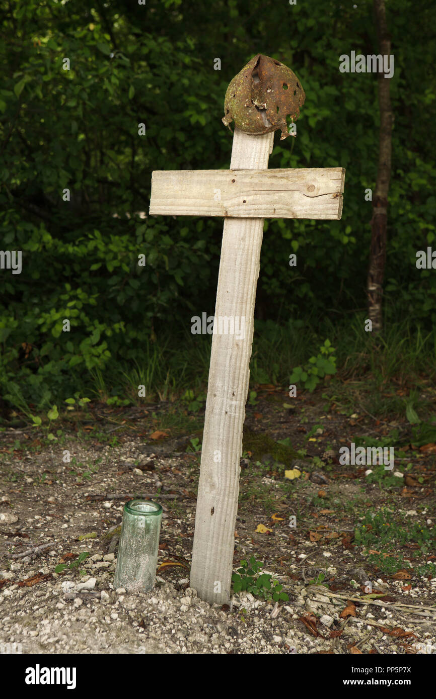 Cenotaph to a French soldier fallen during the First World War in the shape of a wooden cross covered with a French helmet in the Main de Massiges in Marne region in north-eastern France. The Main de Massiges was one of the major sites of the First World War from 1914 to 1918. The area is restored using the original artefacts found in the ground by the Main de Massiges Association since 2009. Stock Photo
