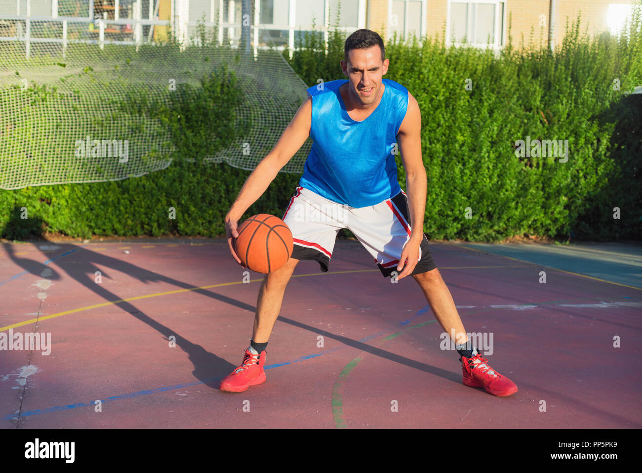 Young man athlete on basketball court dribbling Stock Photo