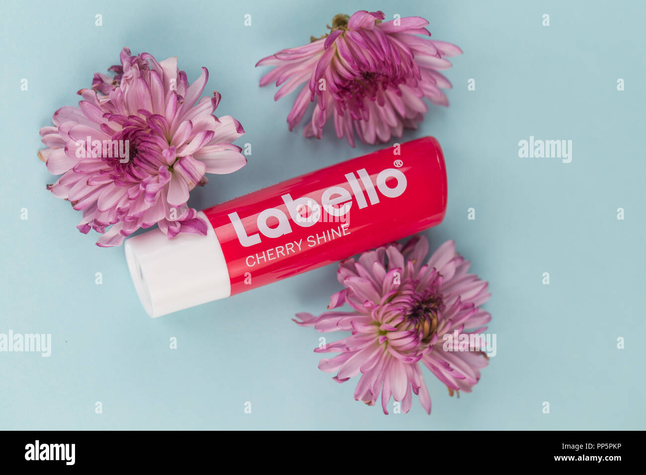 Labello lip balm placed in a soft color background with flowers. Stock Photo