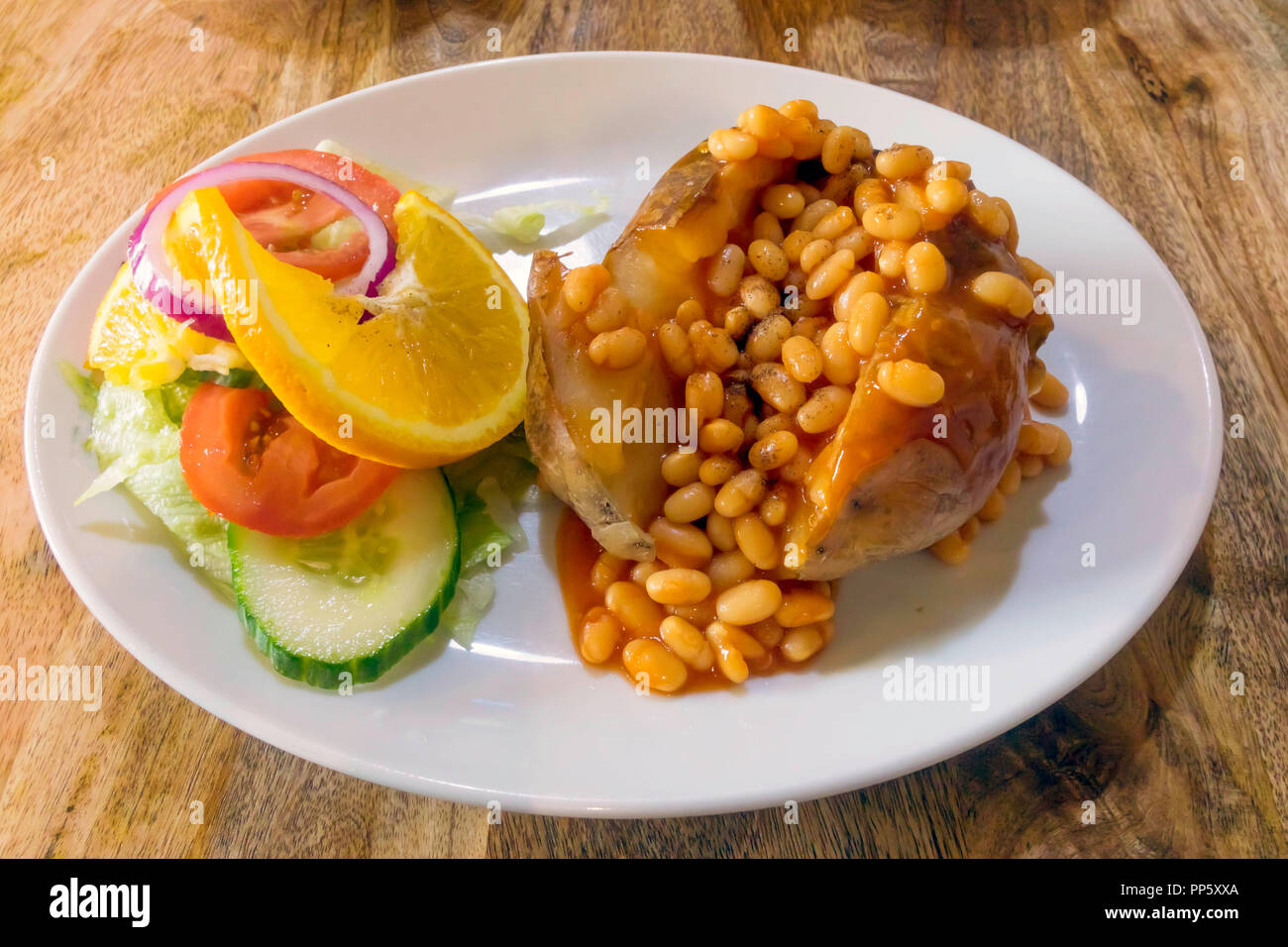 Cheap wholesome lunch jacket potato baked beans and salad Stock Photo