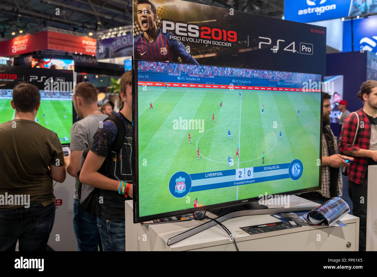 Visitors play the football simulation game PES 2019, Pro Evolution Soccer 2019 at Gamescom, the worlds largest computer and video games fair in Cologne, Germany on 24.8.2018 Stock Photo