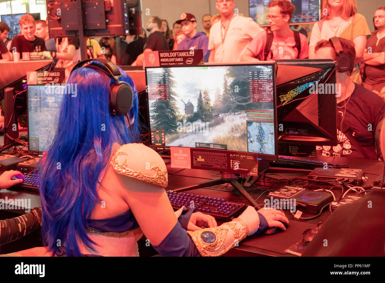 Visitor in cosplay costume sitting in front of a military computer game ...