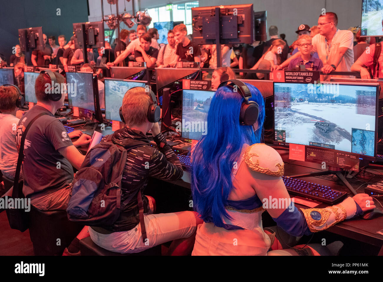 Visitor in cosplay costume sitting in front of a military computer game ...
