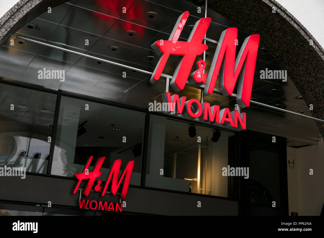 A logo sign outside of a Hennes & Mauritz (H&M) Woman retail store in Munich,  Germany, on September 2, 2018 Stock Photo - Alamy