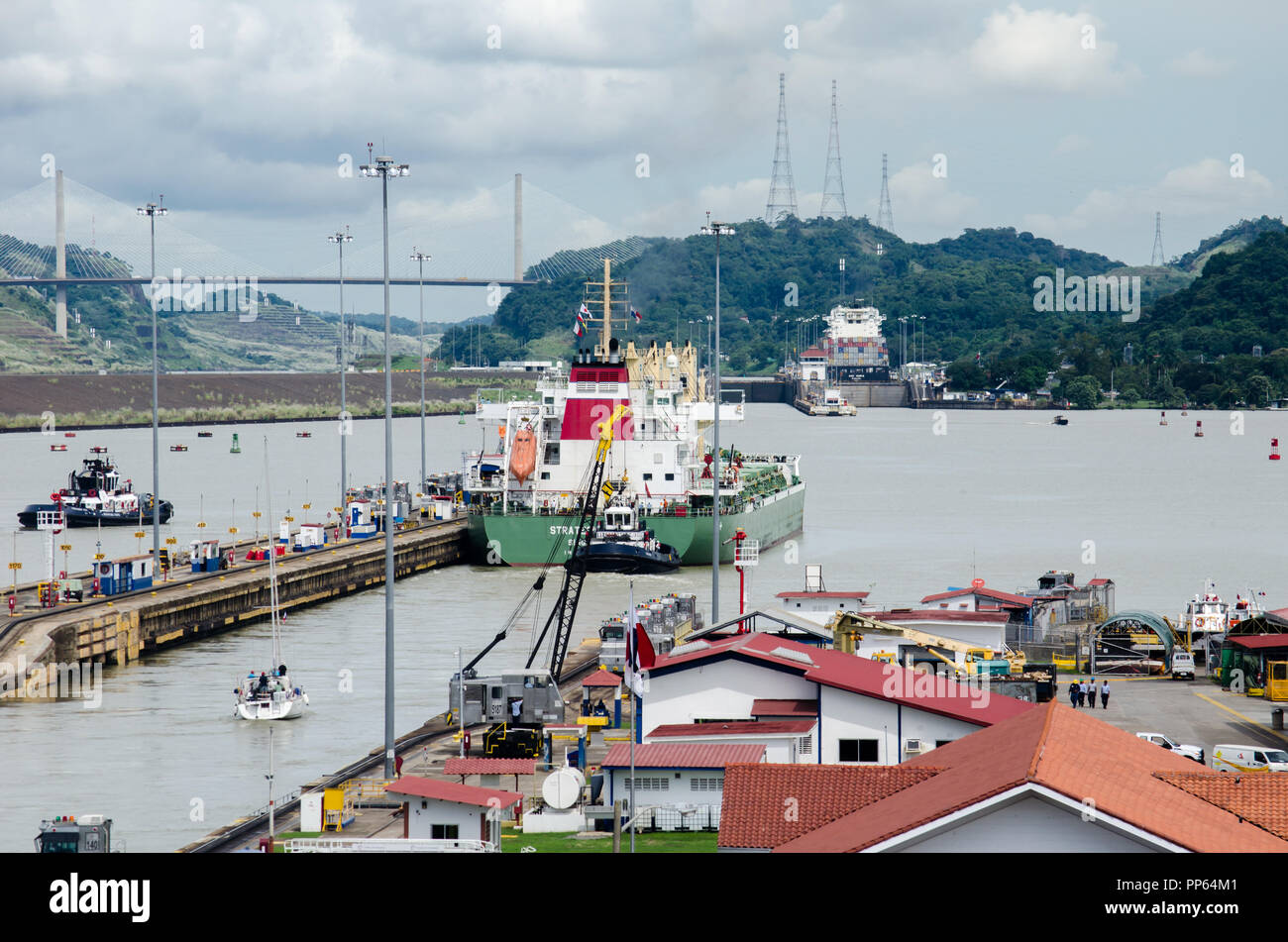 Ships transiting the Miraflores Locks.  Pedro Miguel Locks is seen in the distance, the same as the Centenary Bridge on the left. Stock Photo