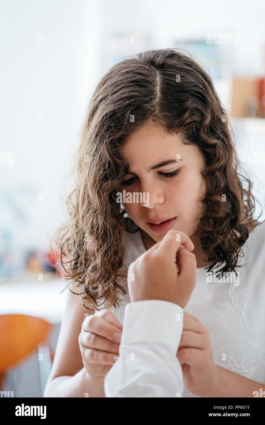 Little girl is helping to dress her brother for a celebration. Stock Photo