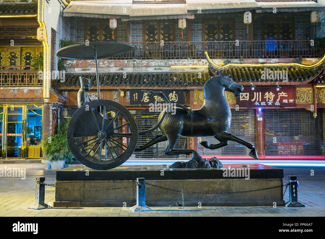 Chengdu, Sichuan province, China - Oct 1st, 2017: Ancient China Chinese Dynasty Palace Bronze Horse Pull General Carriage Statue sculpted by Chen Zhen Bo in QinTaiLu street at night Stock Photo