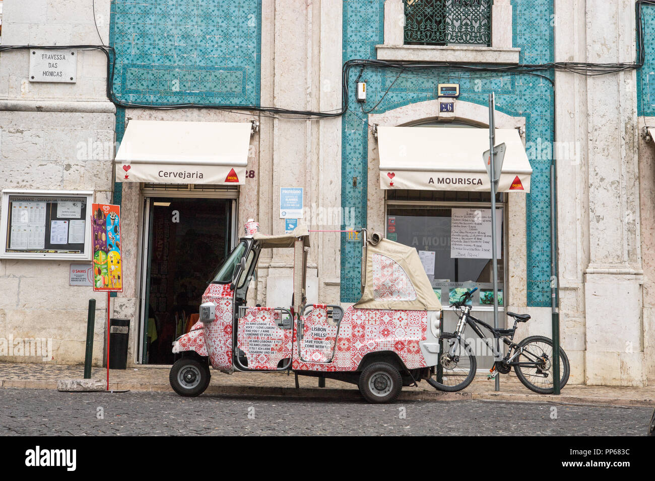 Lisbon, Portugal, TukTuk taxi parked in front of edifice. Stock Photo