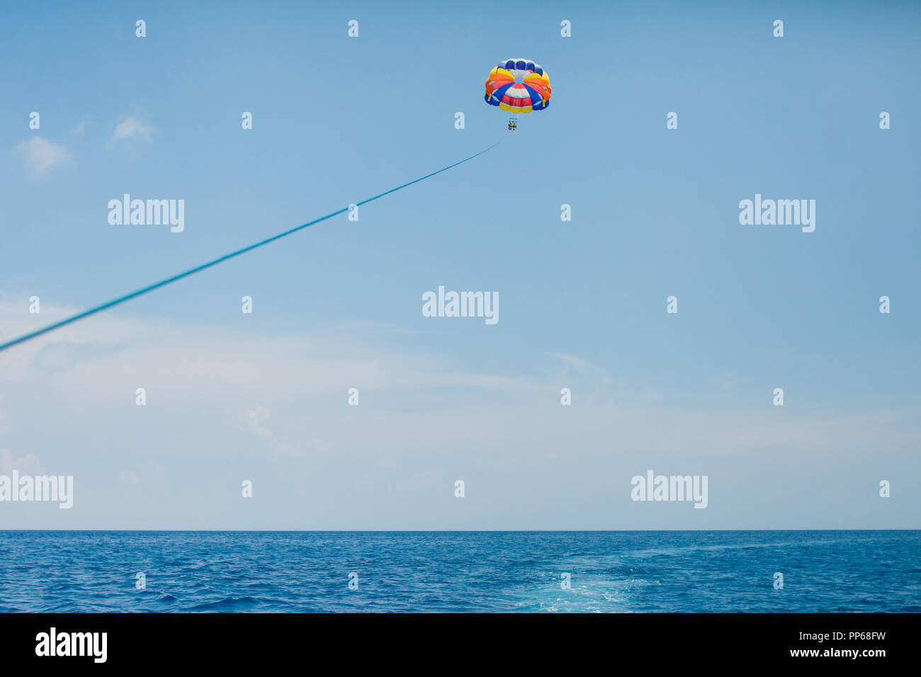 People flying on a colorful parachute towed by a motor boat Stock Photo Alamy