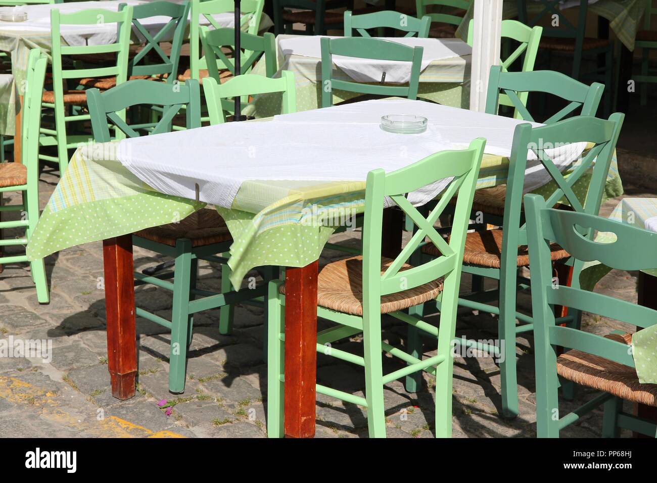 Restaurant tables and green chairs in athens greece
