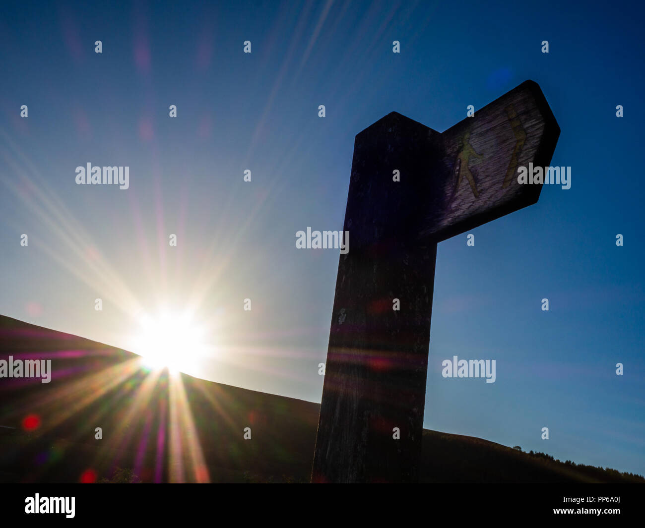 Pathway sign post against a blue sky with the sun setting Stock Photo ...