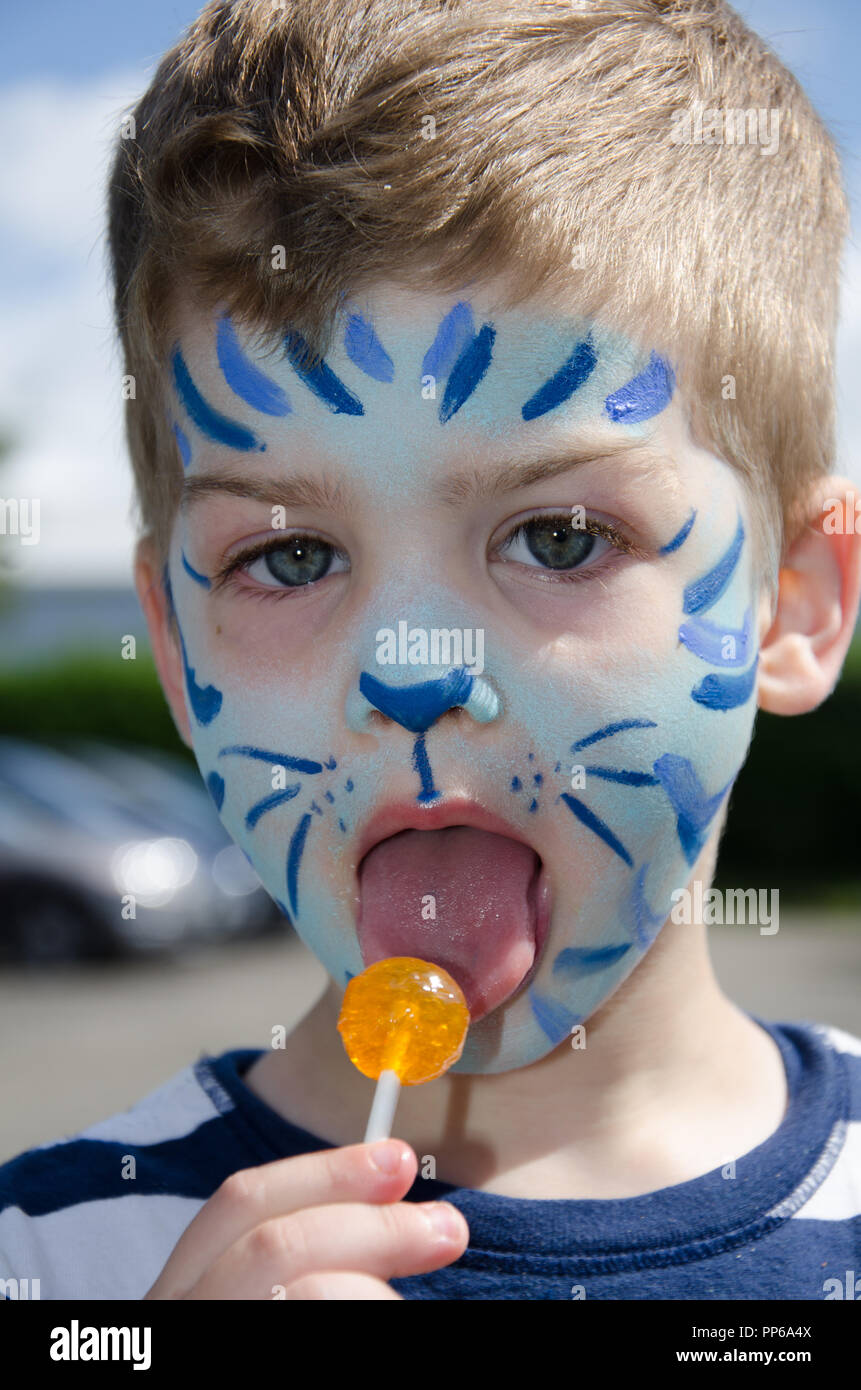 Boy with Blue tiger face paint and lollipop Stock Photo