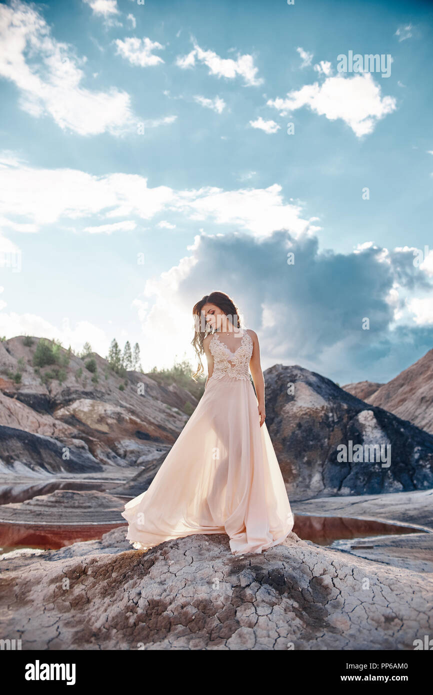Girl In A Light Blue Dress Standing In The Wind With Mountains In