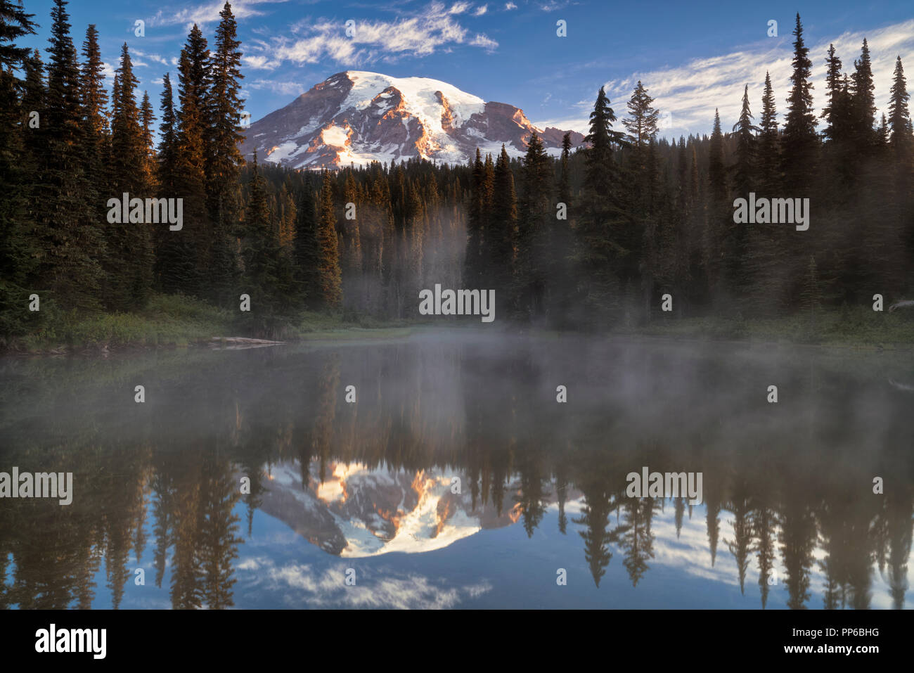 First light glow on Washington’s Mt Rainier from the aptly named Reflection Lakes in Mount Rainier National Park. Stock Photo